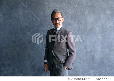一位酷酷的日本男子,背景是灰色。 一位酷酷的日本男子,背景是灰色。 138356382