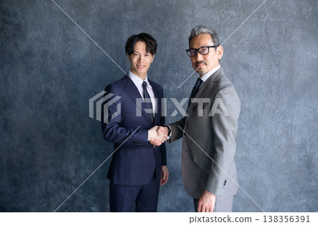 Japanese man shaking hands against a gray background 138356391