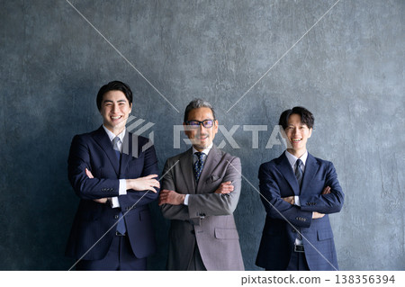 Three Japanese men standing side by side with their arms crossed against a gray background. 138356394
