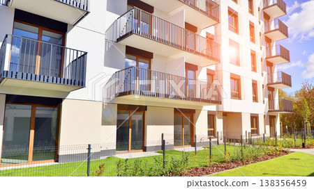 The garden of a modern residential building with a green lawn and a place to relax. Home garden. The garden of a modern residential building with a green lawn and a place to relax. Home garden. 138356459