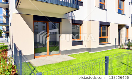 The garden of a modern residential building with a green lawn and a place to relax. Home garden. The garden of a modern residential building with a green lawn and a place to relax. Home garden. 138356466