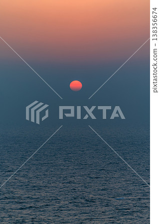 The horizon is bathed in the colors of the sunset, the sun is red, and the sea is enveloped in silence. The horizon is bathed in the colors of the sunset, the sun is red, and the sea is enveloped in silence. 138356674