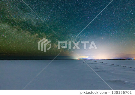 銀河橫跨白雪皚皚的平原，夜空中繁星點點，構成了一幅寧靜的冬日景象。 138356701
