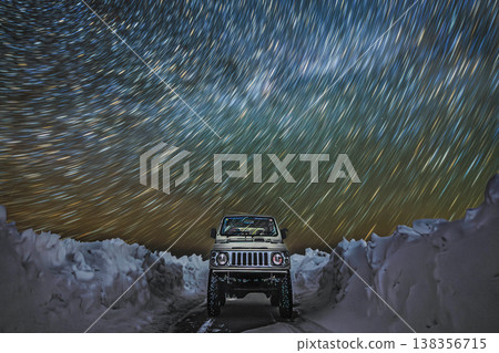 An adventure under the starry sky, a single road sandwiched between snow walls, and a four-wheel drive vehicle. 138356715