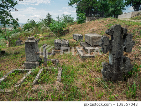 Old graveyard with tombstones and greenery in a rural location during daylight hours Old graveyard with tombstones and greenery in a rural location during daylight hours 138357048