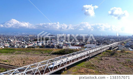 [Magnificent Scenic View] A panoramic view of Mt. Fuji, the cityscape of factories, and the Tokaido Shinkansen crossing the Fujikawa River. 138357071