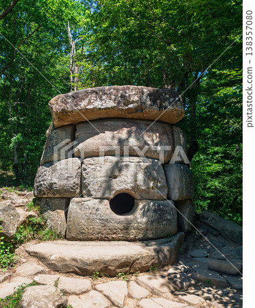 Prehistoric megalithic tomb made of massive stone blocks hidden deep within a vibrant summer forest Prehistoric megalithic tomb made of massive stone blocks hidden deep within a vibrant summer forest 138357080