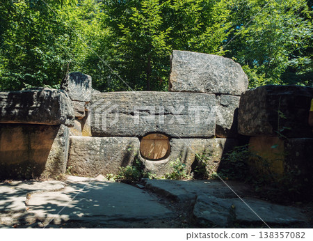 Prehistoric megalithic tomb made of massive stone blocks hidden deep within a vibrant summer forest Prehistoric megalithic tomb made of massive stone blocks hidden deep within a vibrant summer forest 138357082