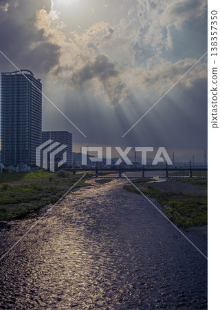 A photograph of an apartment building in Seiseki-Sakuragaoka, the Tama River, and crepuscular rays. 138357350