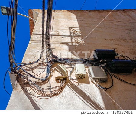 Messy Electrical and Internet Cables on Building Wall Messy Electrical and Internet Cables on Building Wall 138357491
