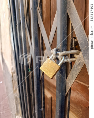 Locked Metal Gate with Padlock on Old House Locked Metal Gate with Padlock on Old House 138357493