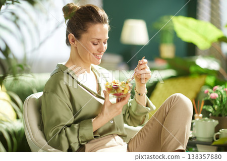 Smiling Woman with Healthy Fruit Snack in Cozy Interior Smiling Woman with Healthy Fruit Snack in Cozy Interior 138357880