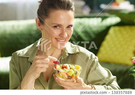 Cheerful Woman with Mixed Fruit Salad at Home Cheerful Woman with Mixed Fruit Salad at Home 138357889