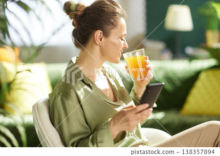 Woman in Green Blouse with Orange Juice and Smartphone Woman in Green Blouse with Orange Juice and Smartphone 138357894