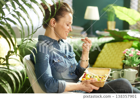 Woman Sitting in Sunlit Room with Nutritious Fruit Snack Woman Sitting in Sunlit Room with Nutritious Fruit Snack 138357901