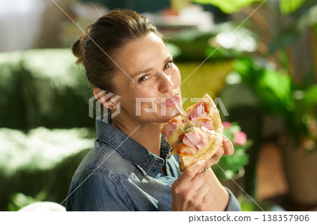 Woman Enjoying Pizza Slice with Melting Cheese String Woman Enjoying Pizza Slice with Melting Cheese String 138357906