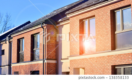 The real estate market in the suburbs. Terraced family homes in newly developed housing estate. New single family houses in a new development area. Residential homes with modern facade.  138358133