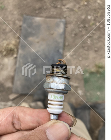 用手拿著農用設備上損壞的火星塞－維修照片 138358952