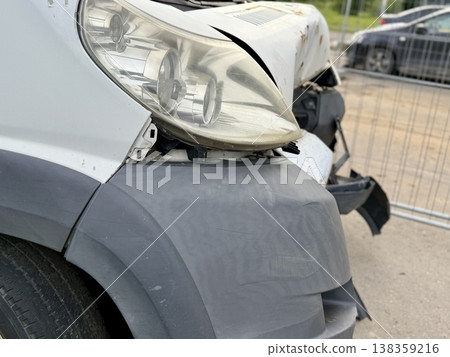This minibus was significantly damaged as a result of a serious head-on collision. A seriously damaged grey minibus, which shows significant collision marks in the front and extensive rust marks. This minibus was significantly damaged as a result of a serious head-on collision. A seriously damaged grey minibus, which shows significant collision marks in the front and extensive rust marks. 138359216