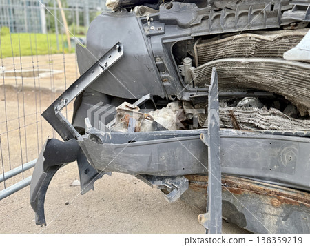 This minibus was significantly damaged as a result of a serious head-on collision. A seriously damaged grey minibus, which shows significant collision marks in the front and extensive rust marks. 138359219