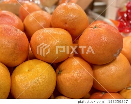 A box of ripe, fresh yellow oranges is for sale on the shelf of a fruit supermarket. Close-up. A box of ripe, fresh yellow oranges is for sale on the shelf of a fruit supermarket. Close-up. 138359237