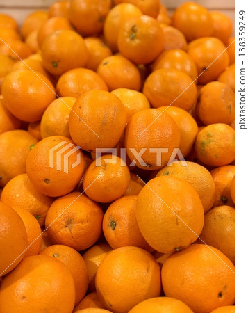 A box of ripe, fresh yellow oranges is for sale on the shelf of a fruit supermarket. Close-up. 138359249