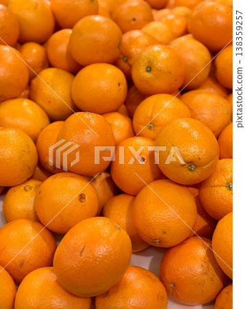 A box of ripe, fresh yellow oranges is for sale on the shelf of a fruit supermarket. Close-up. A box of ripe, fresh yellow oranges is for sale on the shelf of a fruit supermarket. Close-up. 138359257