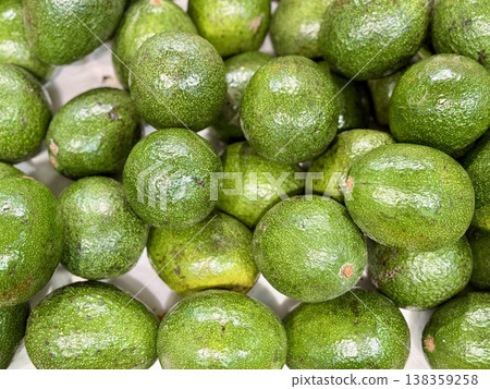 Large rifle green avocados harvested ready to eat are sold on supermarket shelves top view. Healthy eating. Close-up. Large rifle green avocados harvested ready to eat are sold on supermarket shelves top view. Healthy eating. Close-up. 138359258