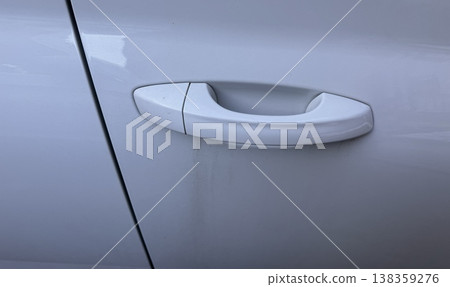 A close-up of a white door handle with a closed cap for a car lock on a clean, modern body, showing smooth lines and elegant design. Efficient transportation systems are essential for economic growth. A close-up of a white door handle with a closed cap for a car lock on a clean, modern body, showing smooth lines and elegant design. Efficient transportation systems are essential for economic growth. 138359276