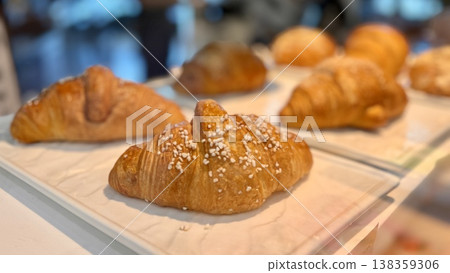 Freshly baked almond croissants with a wide assortment are elegantly laid out in a beautiful showcase for regular visitors. Close-up. 138359306