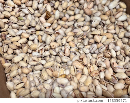 A lot of fried selected clean delicious pistachios for sale in a box at a local specialty market. Close-up. A lot of fried selected clean delicious pistachios for sale in a box at a local specialty market. Close-up. 138359371