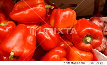 Vibrant red bell peppers are abundant in a market basket, showcasing their freshness and vivid color. Close-up. Vibrant red bell peppers are abundant in a market basket, showcasing their freshness and vivid color. Close-up. 138359399