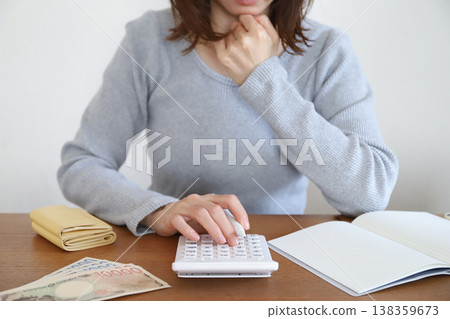 一位正在使用計算機處理家庭財務的女性 一位正在使用計算機處理家庭財務的女性 138359673