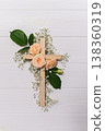 Wooden christian cross with pink roses and gypsophila flowers on a dark shadow wall representing faith and easter resurrection copy space symbolizing faith 138360319