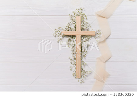 Wooden cross symbolizing christian faith and spirituality, delicate ribbon, and white gypsophila flowers on a clean copy space background remembrance for easter Wooden cross symbolizing christian faith and spirituality, delicate ribbon, and white gypsophila flowers on a clean copy space background remembrance for easter 138360320