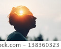 Sun rising above the clouds inside the silhouette of a male head. The way of thinking and psychology of successful man. Positive mindset of businessman concept. 138360323