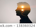 Sun rising above the ocean inside the silhouette of a male head. The way of thinking and psychology of successful mindset of young man. 138360324