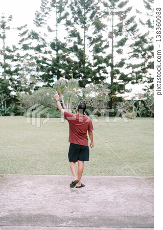 Man walking toward green field lifting one arm in casual gesture Man walking toward green field lifting one arm in casual gesture 138360988
