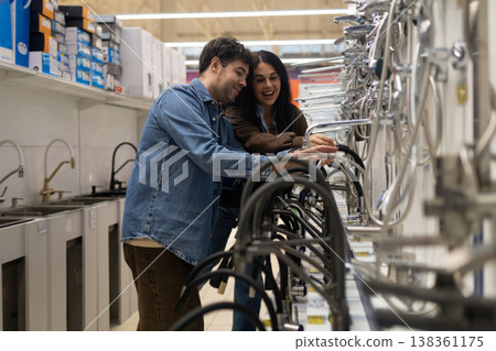 Happy couple selecting new faucets at a hardware store for renovation 138361175