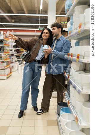 Young couple looking at dishes on shelves in domestic retail store Young couple looking at dishes on shelves in domestic retail store 138361190