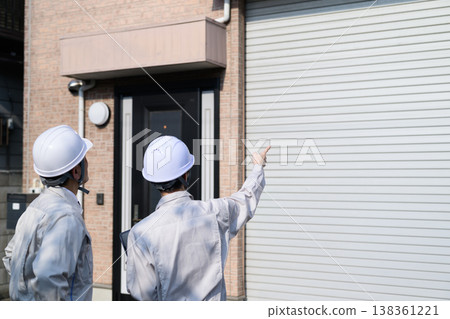 Japanese man in work clothes inspecting a house Japanese man in work clothes inspecting a house 138361221