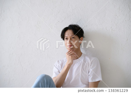 A Japanese man smiling in front of a white wall A Japanese man smiling in front of a white wall 138361229