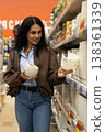 Woman choosing white ceramic flower pots from a retail store shelf 138361339