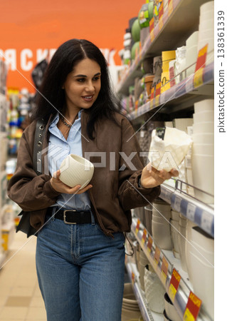 Woman choosing white ceramic flower pots from a retail store shelf Woman choosing white ceramic flower pots from a retail store shelf 138361339