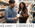 Couple comparing light bulbs, making a purchase decision in a retail aisle 138361342