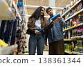Couple is examining a car brush together in the automotive section of a store 138361344