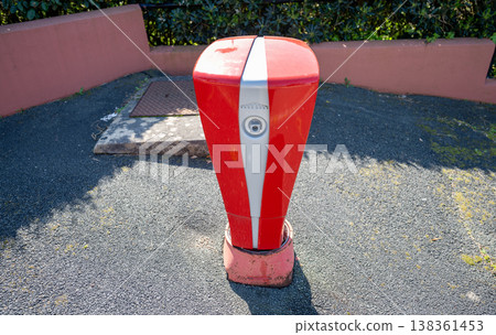 Red automatic parking barrier control post on urban street access system security bollard equipment 138361453