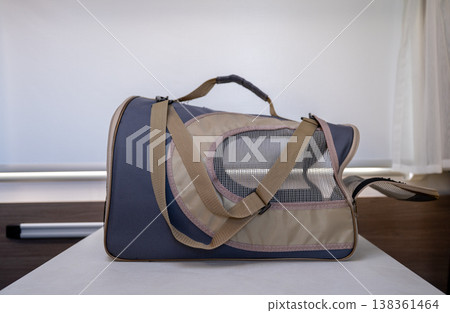 Portable pet carrier bag with mesh ventilation on table indoor travel transport concept Portable pet carrier bag with mesh ventilation on table indoor travel transport concept 138361464