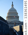 Last beams of golden sunlight on the United States Capitol Building in Washington, DC, with the American flag waving, blue sky backrgound 138361495