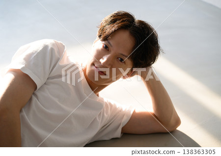 一名日本男子睡在陽光下的地板上。 一名日本男子睡在陽光下的地板上。 138363305